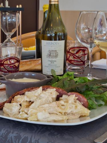 a plate of food with a bottle of wine at Le Champ des Lys in Amancey