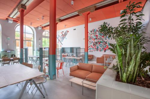 a room with a couch and tables and chairs at The People - Strasbourg in Strasbourg