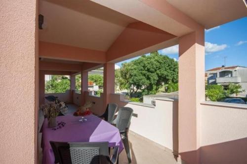 balkon z purpurowym stołem i krzesłami w obiekcie Apartment Perla w mieście Brodarica
