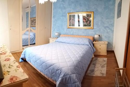 una camera da letto con un letto con una parete blu di B&B Dosso Quarel a Costermano