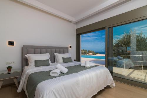 a bedroom with a large bed and a large window at Villa Anna in Zakynthos Town