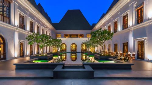 a courtyard in a building with trees and lights at Grand Hyatt Goa in Panaji
