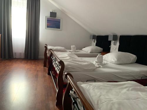 a bedroom with three beds and a window and a staircase at Hotel Kameleon in Tarnobrzeg