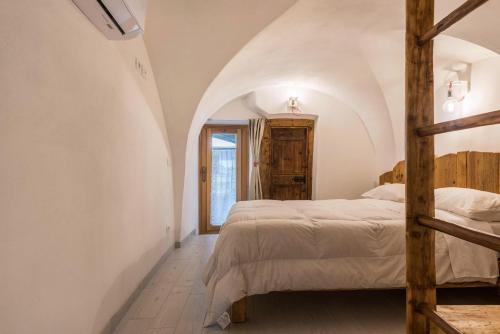 ein Schlafzimmer mit weißen Wänden und ein Bett mit einer Leiter in der Unterkunft Logge dei Paroloti Paolo in San Lorenzo in Banale