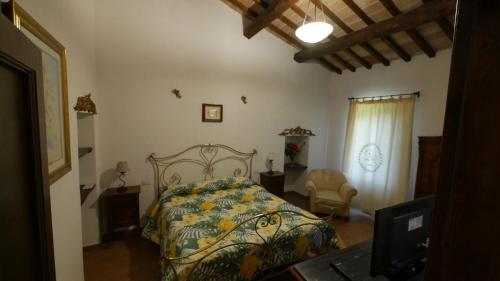 a bedroom with a bed and a desk with a laptop at Casale sul Lago Trasimeno in San Feliciano