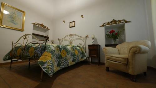 a bedroom with a bed and a chair at Casale sul Lago Trasimeno in San Feliciano