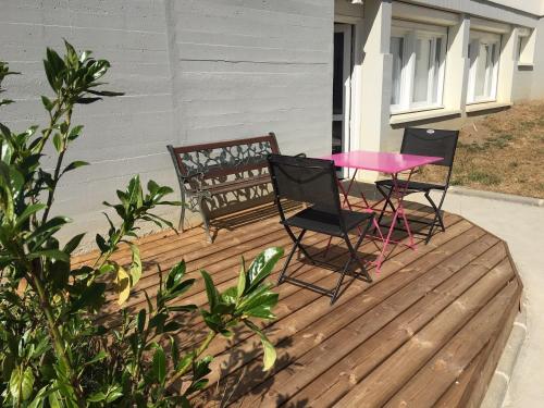 two chairs and a pink table on a deck at Centre Jean XXIII in Annecy
