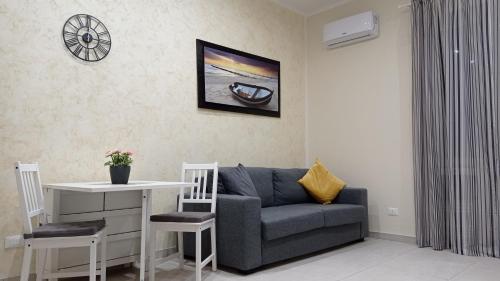 uma sala de estar com um sofá e uma mesa em Casetta Delia em Palermo