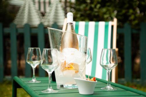 a table with a bottle of wine and wine glasses at LE FRUIT DEFENDU in Rueil-Malmaison