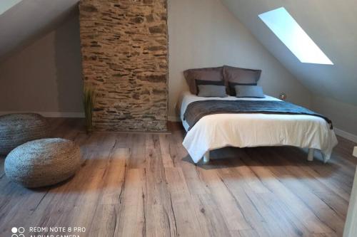 a bedroom with a bed and a brick wall at maison quartier médiéval au pied du château FOUGERES in Fougères
