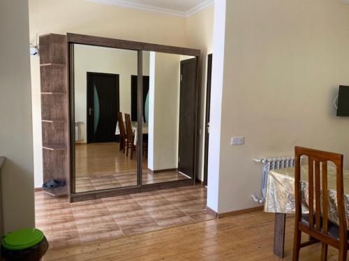 a mirror in a room with a table and chairs at Alp Hotel in Qax