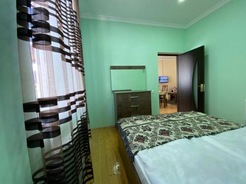 a bedroom with a bed and a dresser and a mirror at Alp Hotel in Qax