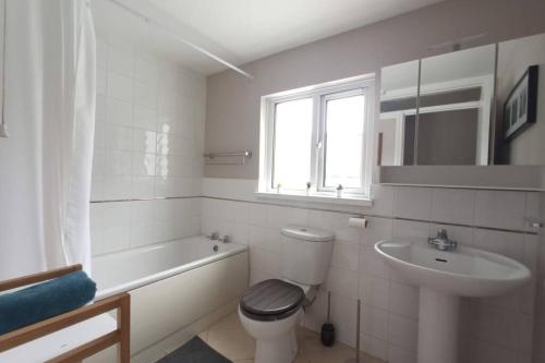 a white bathroom with a toilet and a sink at Argyle House, 10 minute walk from city centre in Derry Londonderry