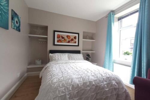 a bedroom with a white bed and a window at Argyle House, 10 minute walk from city centre in Derry Londonderry