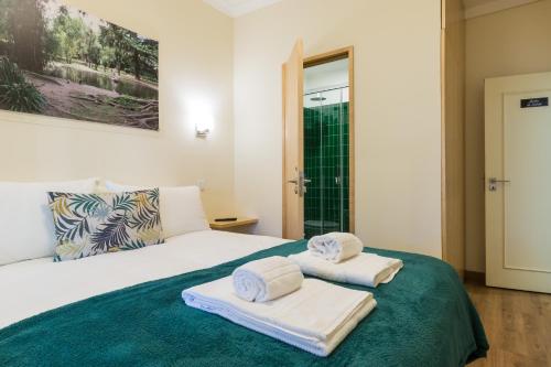 a bedroom with a bed with towels on it at Vita Portucale ! 3 Bedroom Apartment with Private Terrace in Lisbon