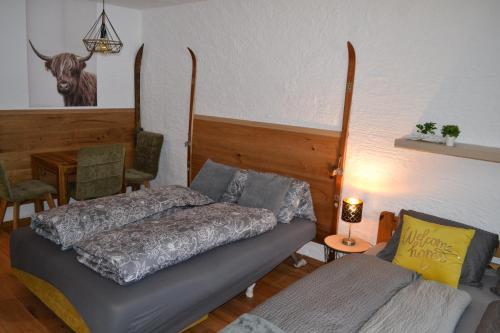 a bedroom with a bed and a couch and a table at Andys Bergblick in Leutasch