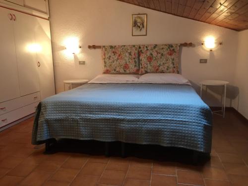a bedroom with a large bed with a blue blanket at Casa Mary in Brenzone sul Garda
