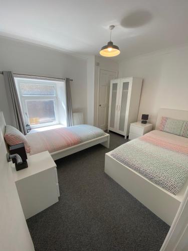 a bedroom with two beds and a window at The Castle Lodge in Tredegar