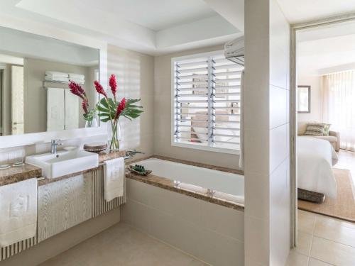 a bathroom with a tub, sink, and mirror at Shangri-La Yanuca Island, Fiji in Voua