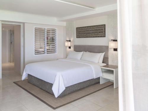 a hotel room with a bed and a dresser at Shangri-La Yanuca Island, Fiji in Voua