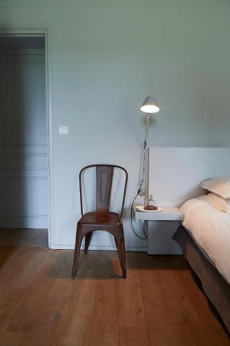 a bedroom with a chair and a bed and a desk at Mas des Songes in Monteux