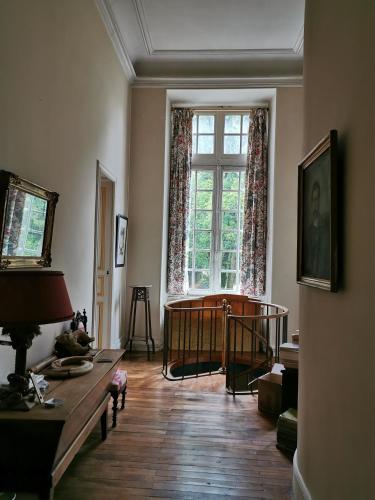 un salon avec une grande fenêtre et une table dans l'établissement Château de Chasseneuil sur Bonnieure, à Chasseneuil-sur-Bonnieure