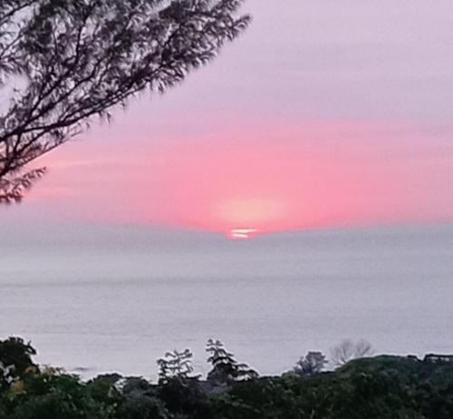 a sunset over the ocean with the sun in the sky at Henry's House On Sea in Hibberdene