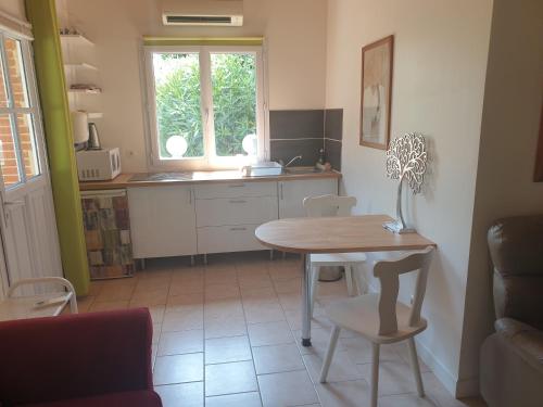 a kitchen with a table and a table and chairs at Appartement à Tournefeuille in Tournefeuille