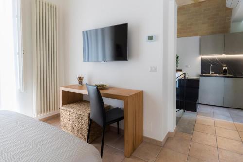een slaapkamer met een bureau en een televisie aan de muur bij Antica Pepice in Matera