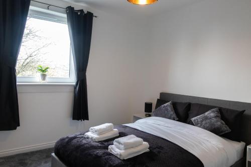 ein Schlafzimmer mit einem Bett mit Handtüchern darauf in der Unterkunft Vion Apartment - Farquhar in Aberdeen