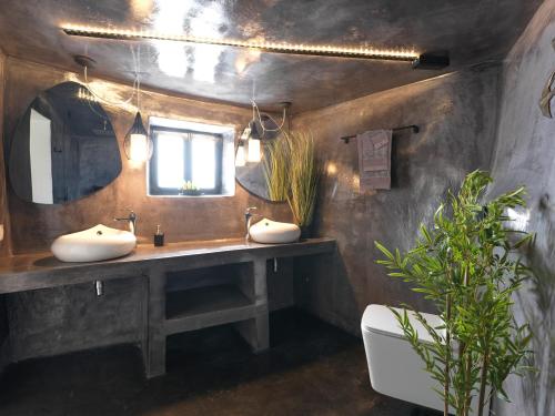 a bathroom with two sinks and a mirror at Secret Gem Suites in Oia