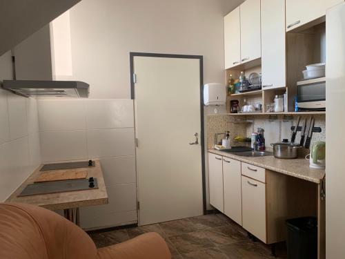 a kitchen with white cabinets and a white door at Rotermanni hostel 4Floor NO LIFT in Tallinn