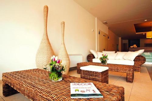 un soggiorno con 2 sedie in vimini e un letto di Residence Riviera Palace Loano - ILI02225-CYC a Loano
