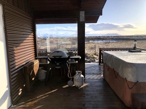 a patio with a grill and a table on a deck at Fögruvallakot Cabin in Hella