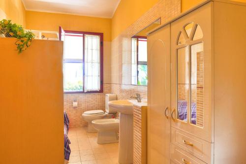 La salle de bains est pourvue d'un lavabo, de toilettes et de fenêtres. dans l'établissement Holiday Home Floridia - ISI02266-F, à Floridia