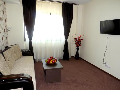a living room with a couch and a table and a television at West Plaza Hotel in Bucharest