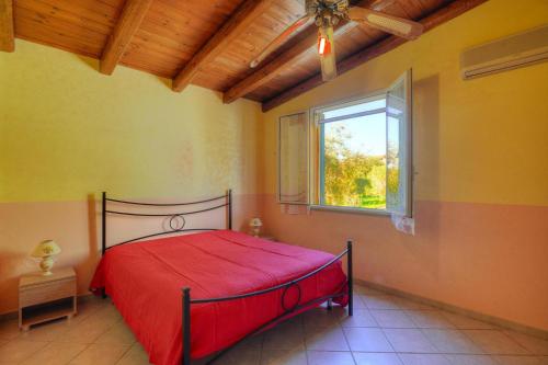sypialnia z czerwonym łóżkiem i oknem w obiekcie Holiday Home Floridia - ISI02274-F w mieście Floridia