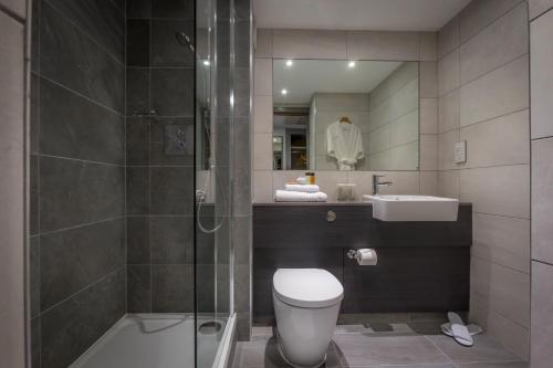 a bathroom with a shower and a toilet and a sink at Maldron Hotel South Mall Cork City in Cork