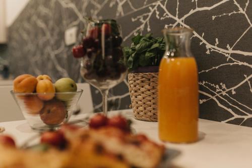 マテーラにあるGiulietta nei Sassiのフルーツプレートとオレンジジュースのボトル1本を用意したテーブル
