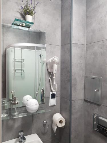 een badkamer met een douche, een wastafel en een spiegel bij Apartament ul Okopowa - Parking płatny in Kołobrzeg