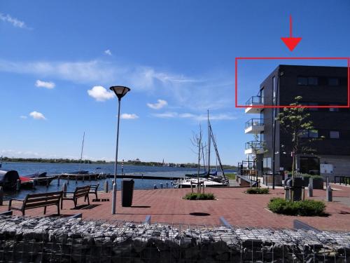 a street light and benches next to a body of water at Vacation apartment Veerse Muze in Kamperland