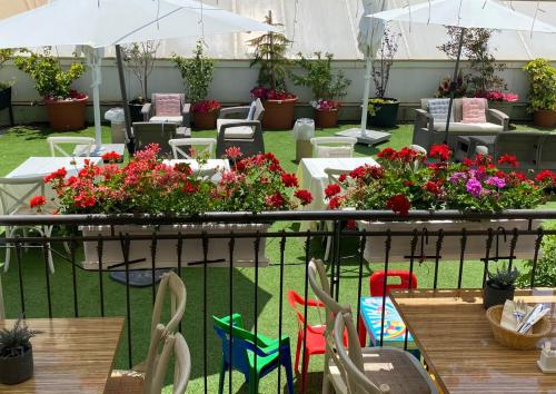 a patio with tables and chairs with flowers and plants at Arroyo Boutique&Business Hotel- By Star Hotels in Nahariyya