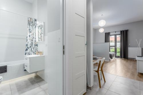 a bathroom with white cabinets and a dining room at Warsaw City Apartments in Warsaw