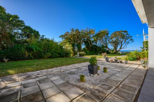a patio with potted plants and a lawn at 302 On Old Sea View Road Chelsea in Port Elizabeth