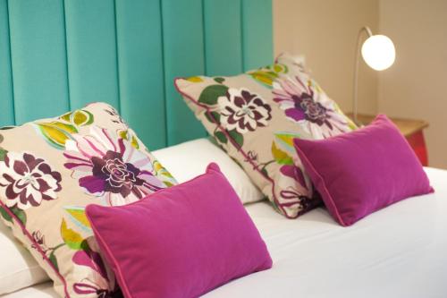 a bed with purple and purple pillows on it at BacHome Terrace B&B in Barcelona