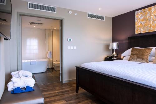 a bedroom with a large bed and a bath tub at Radisson Blu Mammy Yoko Hotel in Freetown