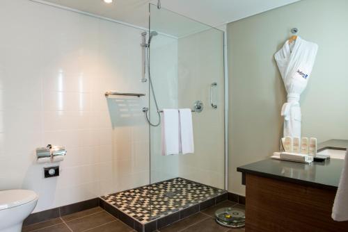 a bathroom with a shower with a glass door at Radisson Blu Mammy Yoko Hotel in Freetown