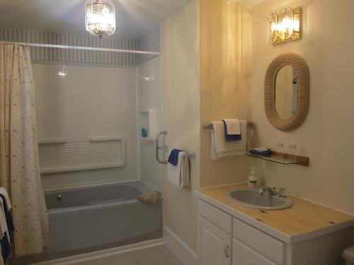 La salle de bains est pourvue d'une baignoire, d'un lavabo et d'une douche. dans l'établissement Salmon River Country Inn, à Head of Jeddore