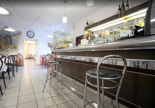 a restaurant with a bar with stools at HOTEL RISTORANTE ROMA in Colico
