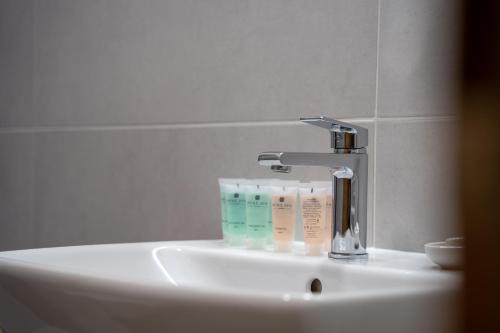 a bathroom sink with a faucet and toothbrushes at Hotel Zelený potok in Pec pod Sněžkou